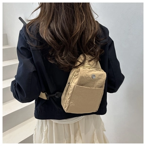 Detail view of khaki nylon crossbody bag showing the wrinkled texture and adjustable strap
