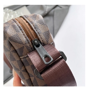 Macro shot of matte black metal zipper and checkered pattern canvas on the shoulder bag