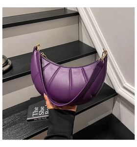 Detail of purple crescent shoulder bag with shell texture and golden metal hardware