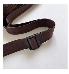 Detail of adjustable woven nylon shoulder strap with buckle on a checkered handbag