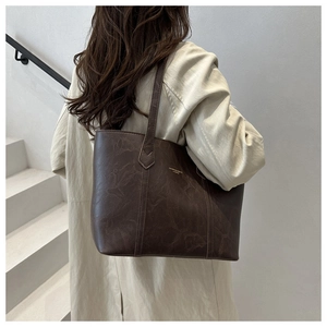 Rear view of model wearing a vintage dark brown tote bag with marble leather texture
