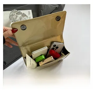 Vista interna che mostra la capacità della borsa a tracolla in ecopelle lucida beige