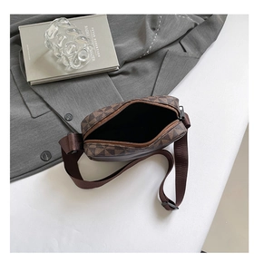 Top view of a brown geometric pattern crossbody camera bag with adjustable shoulder strap