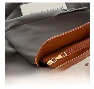 Detail of smooth metal zipper and sweet cherry print on white leather handbag