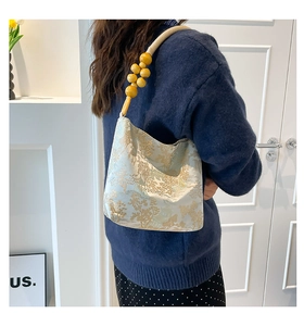 Detail of vintage underarm bag with landscape brocade fabric and wooden bead handle
