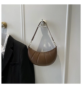 Detail of dark brown crescent bag featuring pleated quilting and gold metal buckle