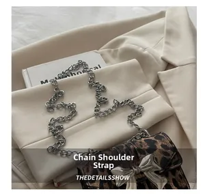 Close-up of leopard print mini bag featuring silver chain strap and bow-shaped metal clasp