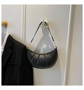 Detailed view of black crescent shoulder bag featuring unique vertical quilted pleated texture