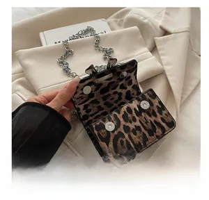 Detail of leopard print mini bag showing secure double magnetic hardware snap closure
