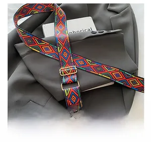 Detail of adjustable woven shoulder strap with colorful geometric patterns and leather ends