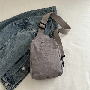 Sac de poitrine minimaliste en nylon gris clair pour femme sur jean bleu