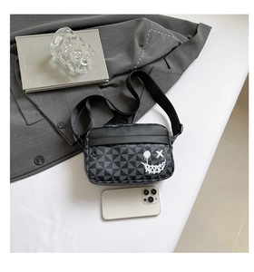 Close-up of stylish urban crossbody bag with geometric pattern and white smiley face
