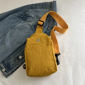 Sac de poitrine en nylon jaune vif avec bandoulière réglable sur fond en denim