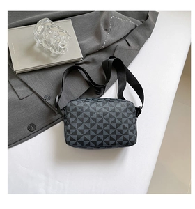 Detail of square camera bag featuring grey geometric triangle patterns and wide strap