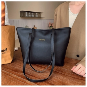 Detalle macro del bolso tote de cuero PU negro con elegantes letras doradas en la superficie