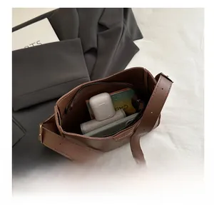 Sac seau en cuir marron foncé montrant l'espace de rangement et le logo de mode