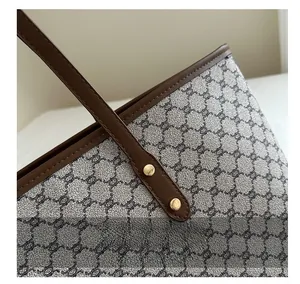 Close-up of vintage monogram tote bag featuring leather trim and golden metal rivets