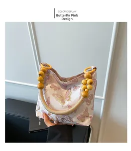 Dettaglio borsa a farfalla rosa con manico in perline e cinturino etnico intrecciato