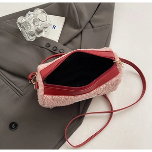 Vue détaillée du sac bandoulière en peluche rose avec garniture en cuir rouge