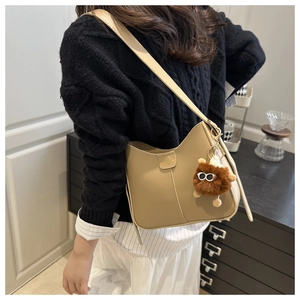 Détail du sac seau kaki avec surpiqûres et charm de monstre en peluche marron