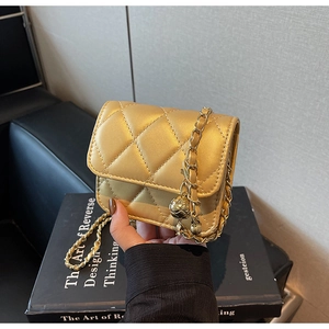 Detail of gold quilted mini bag with metallic chain strap and adjustable golden ball buckle
