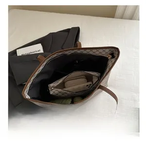 Macro shot of large brown monogram tote bag interior showing the matching pouch and high capacity