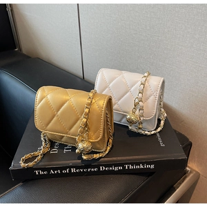 Detail of quilted leather mini bags with chain straps and golden decorative balls