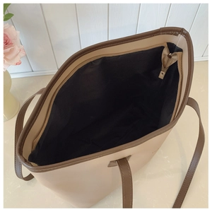Detailed interior view of a large beige tote bag with brown trim and secure zipper closure