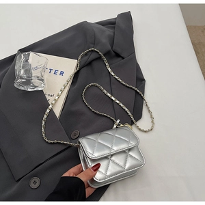 Detail shot of silver quilted mini crossbody bag with metallic finish and chain strap