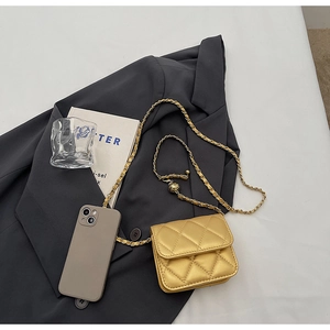 Detail of champagne gold quilted mini bag with adjustable golden ball chain strap