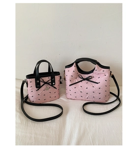 Detail of pink bags with pleated texture, bow patterns, and 3D ribbon embellishments