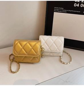 Detail of gold and white quilted mini square bags with elegant metal chain straps