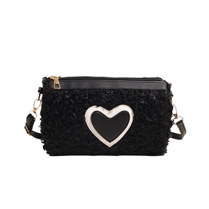 Sac cylindre chic en peluche noire avec détail cœur blanc et finitions dorées