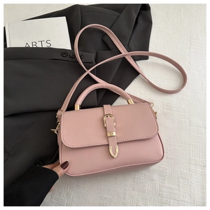 Detail of pink faux leather handbag featuring a golden buckle and stylish textured design