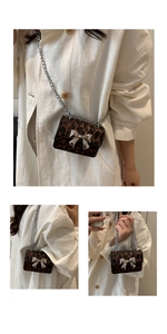 Detail of leopard print mini crossbody bag with silver mirror bow and metal chain strap