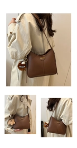 Sac seau en cuir mat marron avec logo métallique et peluche sur le mannequin