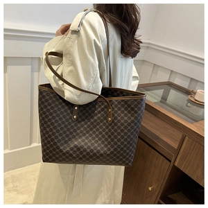 Detail of vintage monogram tote bag featuring leather straps and gold metal rivets