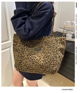 Detail shot of leopard print tote bag featuring a front pocket with FASHION & BAGS label