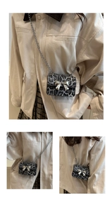 Detail of leopard print chain crossbody bag with a large silver metal bow accessory