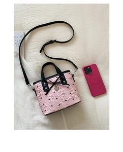 Dettaglio mini borsa tote rosa con motivi a fiocco nero e ciondolo in metallo a cuore