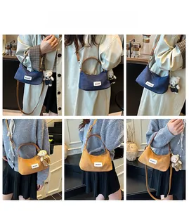Detail view of denim and corduroy patchwork handbag showing multiple carrying styles