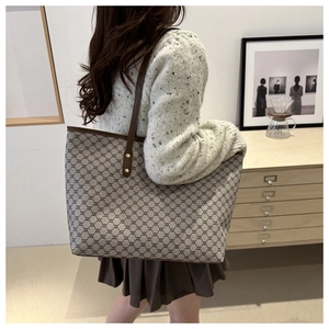 Side view of large geometric pattern tote bag on model shoulder in warm interior