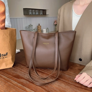 Retro large brown tote bag for women with gold lettering on a wooden table setup