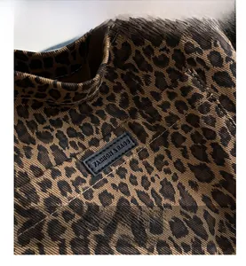 Close-up of leopard print canvas bag with stitched black leather Fashion & Bags label