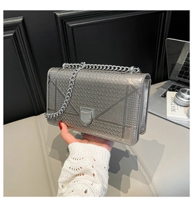 Dettaglio della borsa a catena argento metallizzato con trapuntatura geometrica e chiusura