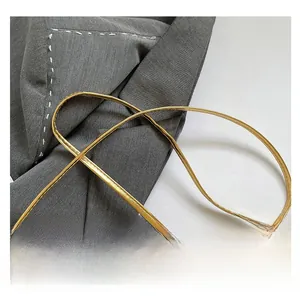 Detail of a bright gold sequin handbag showing textured leather and metallic chain strap