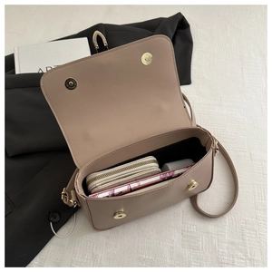 Top view of open beige leather crossbody bag showing internal capacity and magnetic buckles
