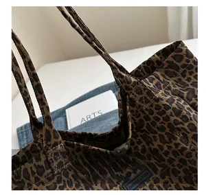 Close-up of leopard print canvas tote bag showing stitching quality and logo detail