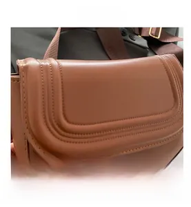 Close-up of brown PU leather shoulder bag featuring unique U-shaped quilted stitching