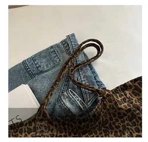 Detail view showing dual handles and leopard print texture on a large canvas tote bag
